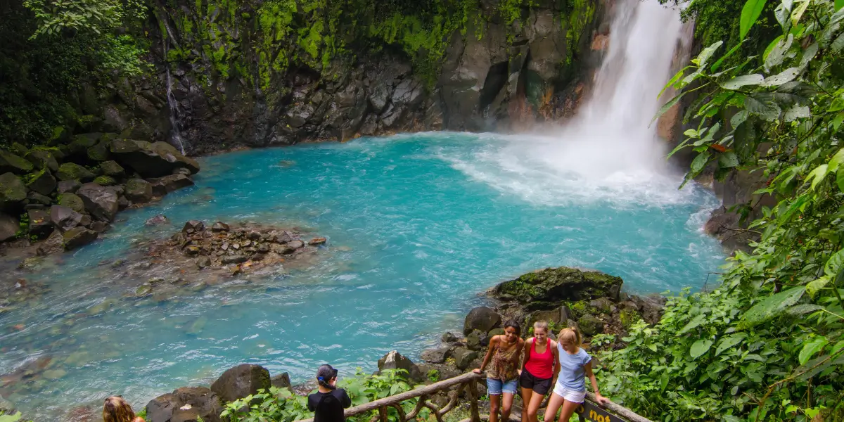 View of the stunning Rio Celeste Waterfall surrounded by lush rainforest in Tenorio Volcano National Park, Costa Rica.