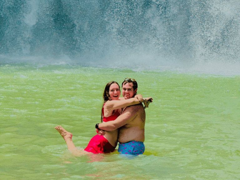 Couple standing in front of Llanos de Cortés Waterfall, a hidden gem near La Fortuna, Costa Rica.